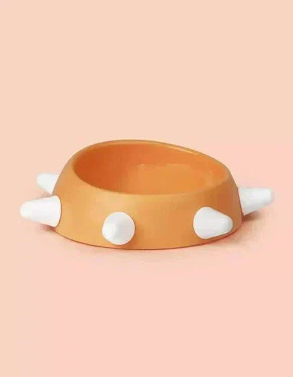 Eco-friendly sloping dog bowl with orange color and white studs.